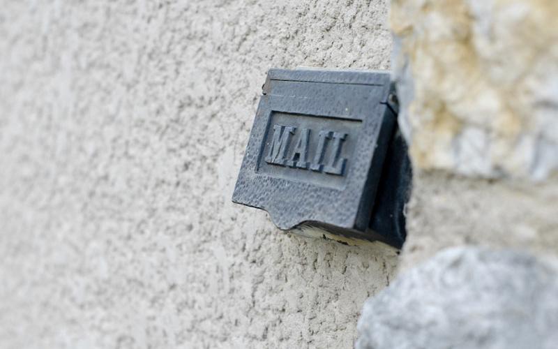 Close-up of mail slot and stone